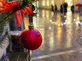 Rainy  Christmas decoration Tallinn  city Red ball on green tree  spruce branch  blurred yellow evening light life style  ur Royalty Free Stock Photo