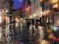 rainy city evening rainy street people walk with umbreellas city blurred light wet pavement medieval houses in Tallinn old town