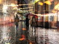 Rainy city night light street reflection people with umbrellas buildings blurred light red yellow bokeh vew from window urban Tall Royalty Free Stock Photo