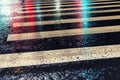 Rainy city street reflections on asphalt road crosswalk. City life in night in rainy season abstract background. Night asphalt Royalty Free Stock Photo