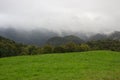 Rainy clouds in mountains. Foggy morning in green valley. Scenic landscape with clouds and fog. Royalty Free Stock Photo