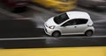 Rainy day in the city: A driving car in the street splashing water in motion blur Royalty Free Stock Photo