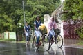 On a rainy day girls going to school on bicycles