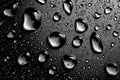 On a rainy day, light causes water droplets to create a sparkling effect on a smooth black surface Royalty Free Stock Photo