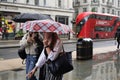 Rainy day in London city centre with people and umbrellas, England 2021