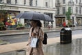 Rainy day in London city centre with people and umbrellas, England 2021