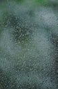 Rainy day, raindrops on wet window glass, vertical bright abstract rain water background pattern detail, macro closeup, detailed