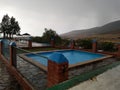 Rainy day at the swimming pool of a small spain village. Royalty Free Stock Photo