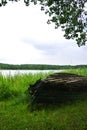 Rainy day at Trakai natural park, a view to a flipped over old big wooden boat, a lake and a forest Royalty Free Stock Photo