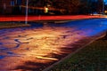 Rainy night in the big city, light from the shop windows reflected on the road Royalty Free Stock Photo