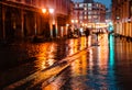 Rainy night in a big city, reflections of lights on the wet road surface. Royalty Free Stock Photo