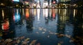 Rainy night city reflection in puddle with floating autumn leaves Royalty Free Stock Photo