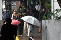 rainy season in jakarta people wear umbrellas
