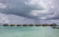Rainy and stormy clouds over wooden bungalows stretching out across the lagoon in Bora Bora island Royalty Free Stock Photo