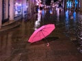 Rainy street pink umbrella in old town of tallinn blurring bokeh city light people walking under rainy sky Royalty Free Stock Photo