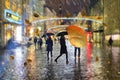 Rainy street rain drops on window glass people walk Autumn leaves fall,blurred evening city bokeh light  lifestyle scene weather f Royalty Free Stock Photo