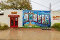 Rainy view of the Greetings From Austin Mural