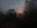 Rainy weather, heart writing on glass sweating at sunset