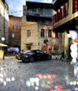 Rainy windows view on city street medieval houses and car on pavement urban lifestyle Royalty Free Stock Photo