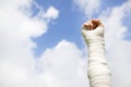 Raise bandaged arm with blue sky background