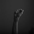 Raised clenched fist against a dark background, power, protest concept