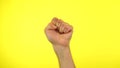 Raised fist on yellow background political protest to showinh his power. clench fist.