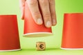 A raised glass and a wooden cube with a euro symbol underneath, the concept of thimble gambling and its harm