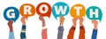 Diverse hands raising speech bubbles that form the word growth to represent collaborative business progress Royalty Free Stock Photo