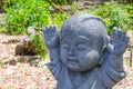 Raised hands up motion of Jizo little stone buddha statue.