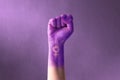 Raised purple fist of a woman for international women`s day and the feminist movement. March 8 for feminism, freedom