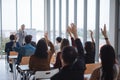Raised up hands and arms of large group in seminar class room to agree with speaker at conference seminar meeting room. Royalty Free Stock Photo