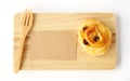 Raisin roll, note paper and fork on wooden tray isolated on whit