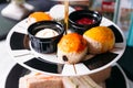 Raisin Scone and Plain Scone on black and white color plate. Served with jam and butter