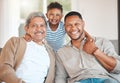 Raising a prince. Portrait of a mature man sitting with his son and holding his grandson at home. Royalty Free Stock Photo