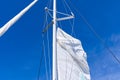 Raising the sail on a yacht. Young man captan lifting the sail of catamaran yacht during cruising Royalty Free Stock Photo