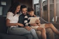 Raising a smart little boy. an adorable little boy using a digital tablet with his mother and father on the sofa at home Royalty Free Stock Photo