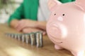 Raising stacks of coins and piggy bank on table Royalty Free Stock Photo
