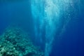 Raising underwater bubbles in the blue sea Royalty Free Stock Photo