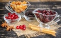 Raisins in a bowl, cranberries, cinnamon and anise on wooden ta