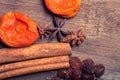 Raisins, cinnamon, anise and dried apricots lying on an old wood