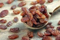 Raisins in a spoon on a wooden table. heap of black raisins close up. selective focus Royalty Free Stock Photo