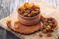 Raisins in a wooden bowl on an old burlap. Royalty Free Stock Photo