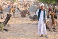 A Rajasthani camel trader surrounded by camels, in India.