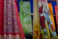 Rajasthani womens clothes are hanging for sale , being displayed in a shop at famous Sardar Market and Ghanta ghar Clock tower in