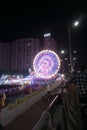 Rajkot, Gujarat, India, 06-09-2023, Portrait View of Glowing Wonder: Vibrant Neon Ferris Wheel at Night