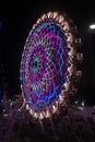 Rajkot, Gujarat, India, 06-09-2023, A Tapestry of Light: Neon-Colored Lights and Ferris Wheel Painting a Lively Canvas