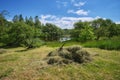 Rake and hay stack on rural landscape. Pond or river