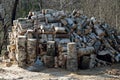 A rake leaning on a big pile of logs