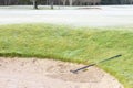 Rake in sand bunker at golf links course green for golfers Royalty Free Stock Photo