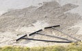 Rake in sand bunker at golf links course green for golfers Royalty Free Stock Photo